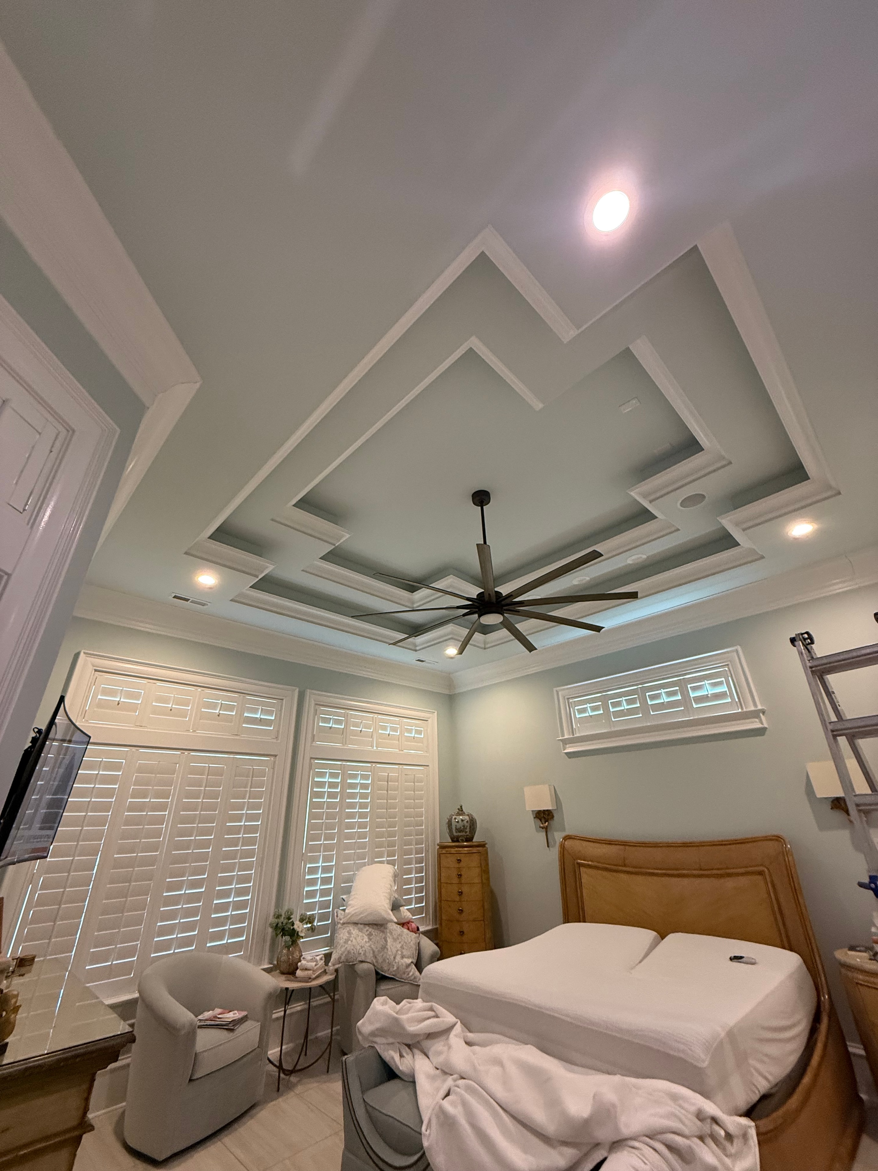 Master bedroom with coffered ceiling and ceiling fan