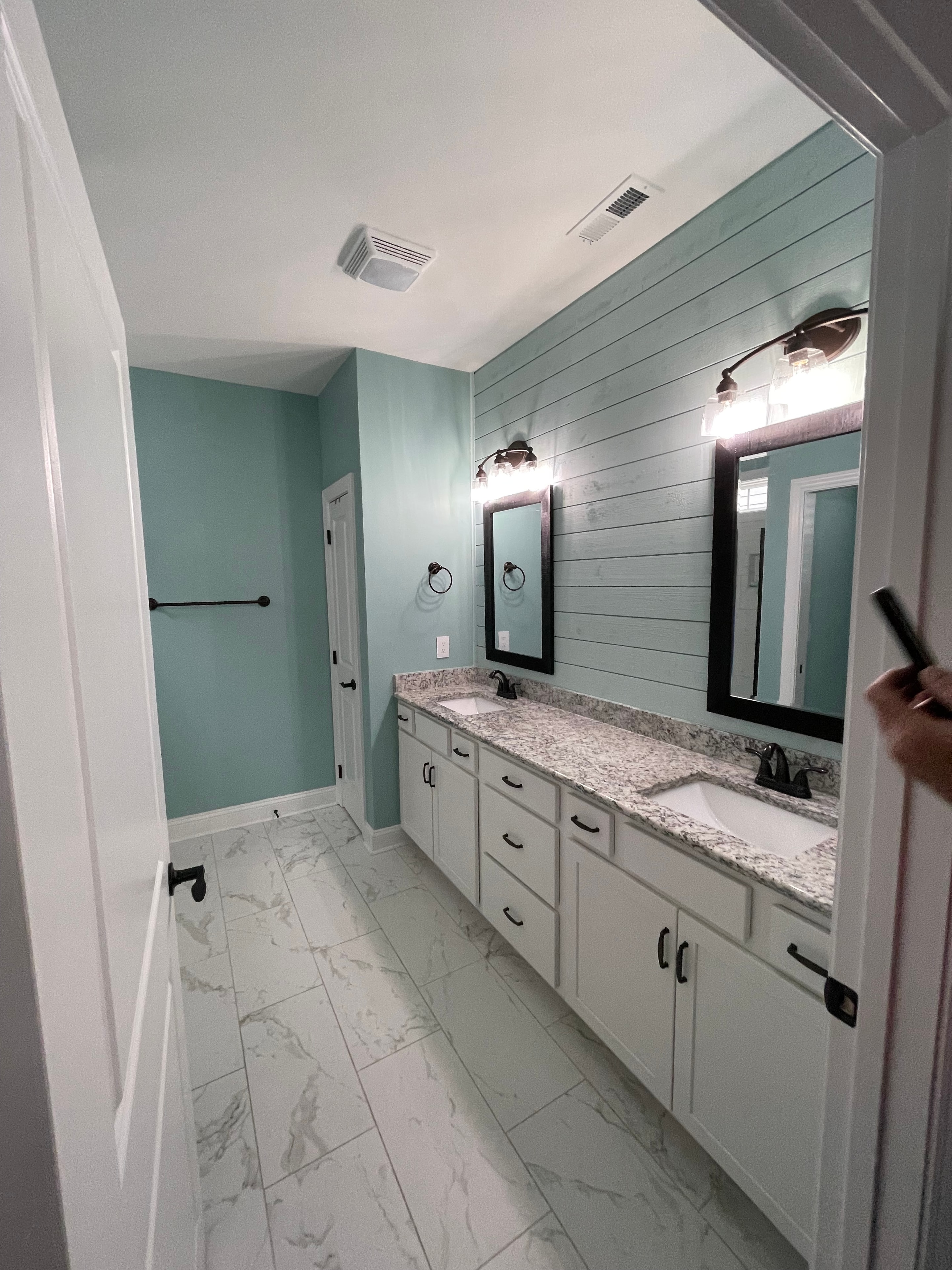 Master bathroom with shiplap ceiling, marble tile, and soaking tub