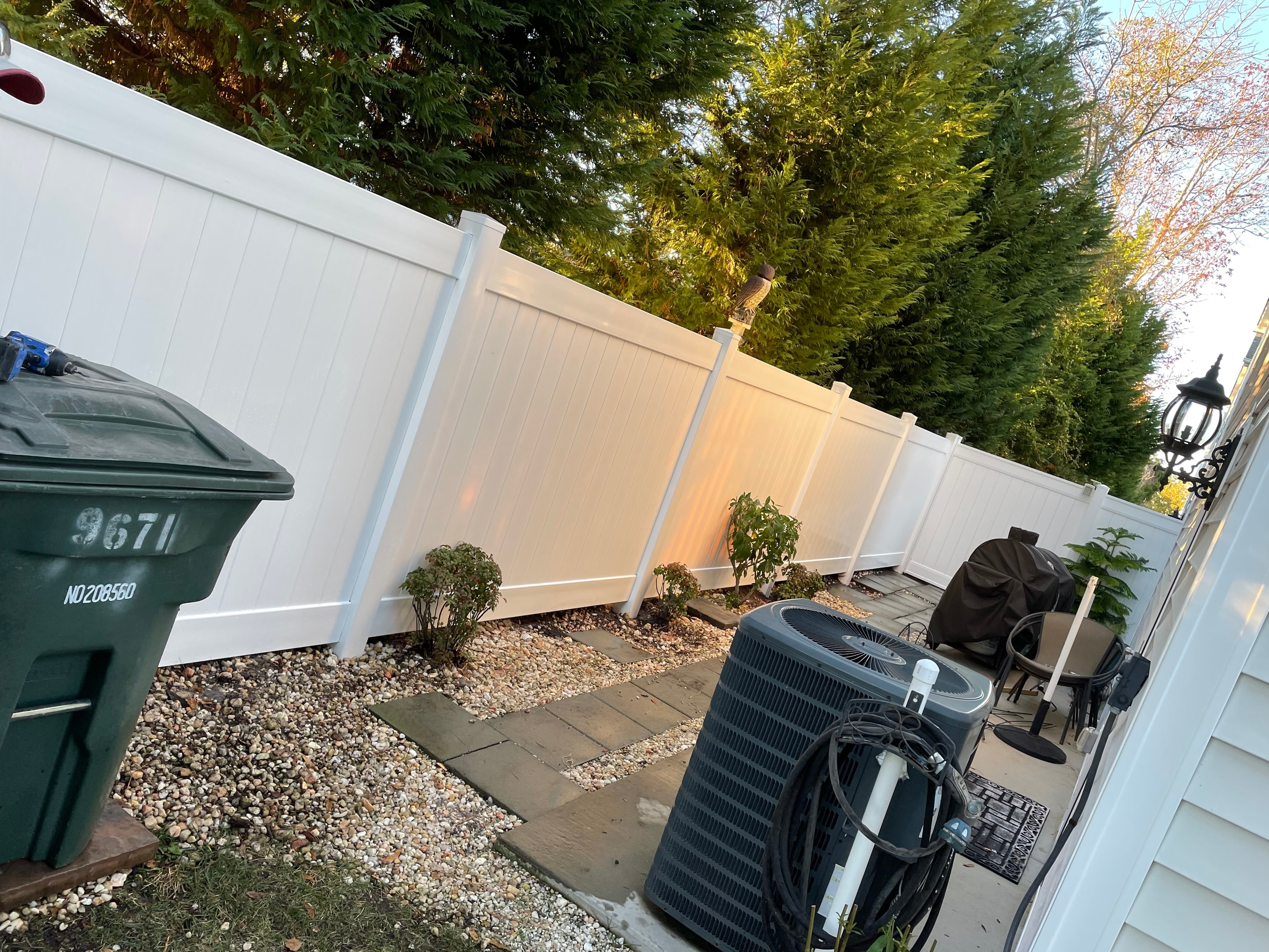 Vinyl privacy fence and trash can enclosure installation