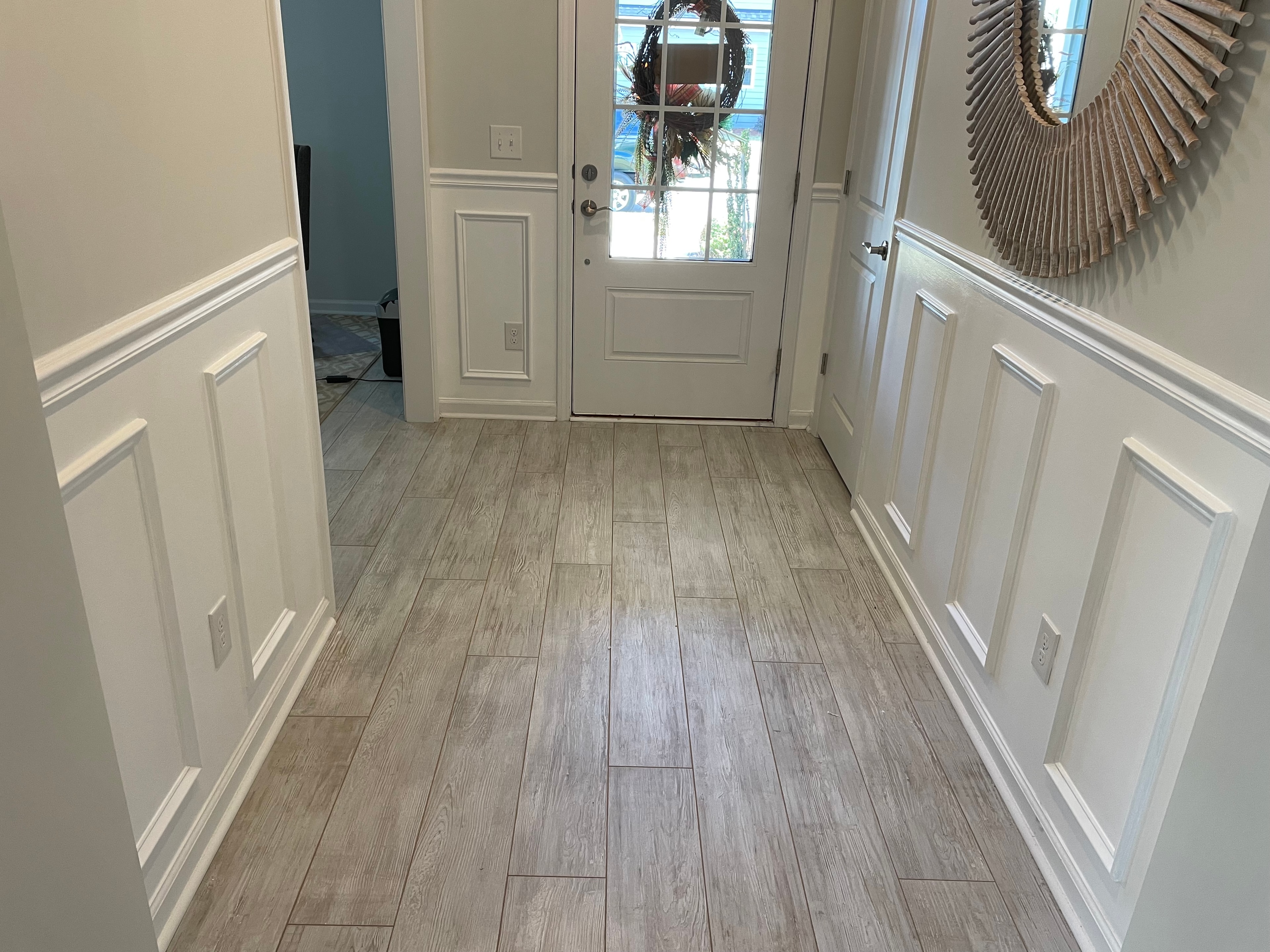 Entryway with wainscoting and wood-look tile flooring